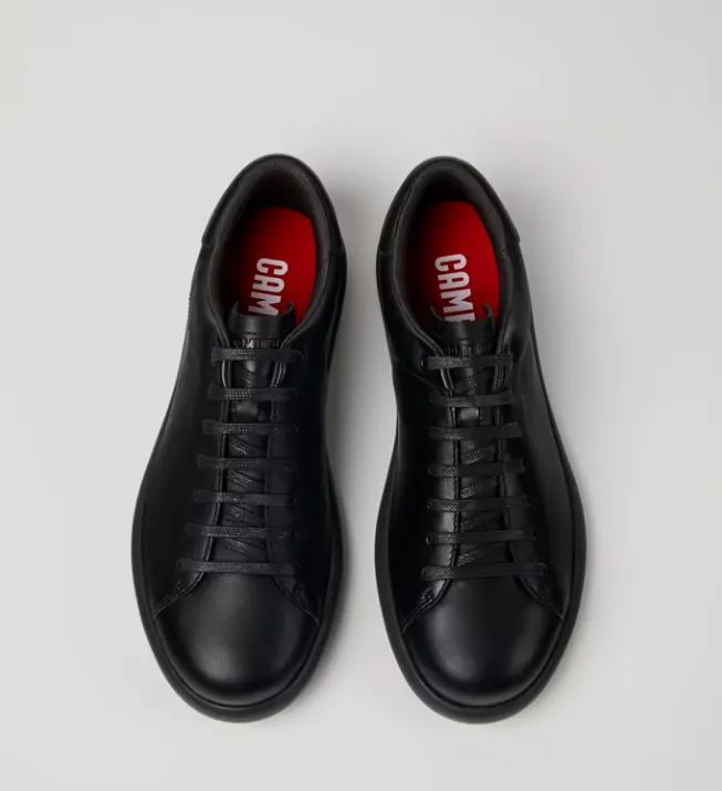 Certainly! To optimize the title for an e-commerce product, its important to include key selling points, relevant adjectives, and any specific details that might attract potential buyers. Heres an optimized title:

Camper Mens Pelotas Soller Sneakers - Sleek All-Black Leather Casual Shoes